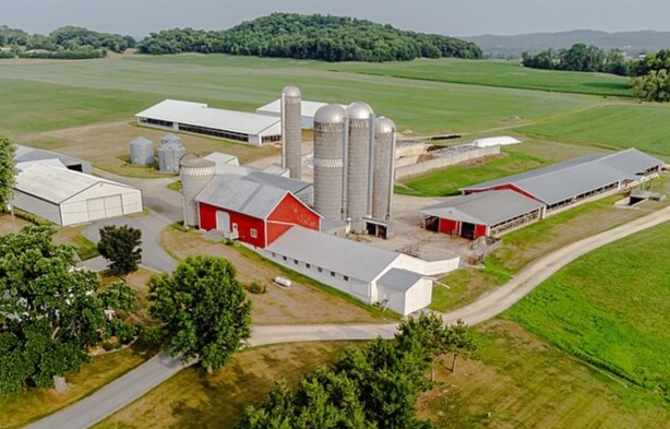 Aerial view of modern dairy farm complex with silos, red barn, and farm buildings